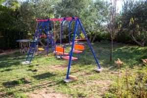einen Spielplatz mit zwei Schaukeln im Hof in der Unterkunft Apartments with a parking space Barbat, Rab - 16245 in Rab