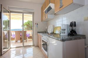 eine Küche mit einer Arbeitsplatte und einem Geschirrspüler in der Unterkunft Apartments with a parking space Barbat, Rab - 16245 in Rab