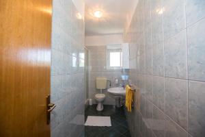 ein Badezimmer mit Toilette und Waschbecken in der Unterkunft Apartments with a parking space Barbat, Rab - 16245 in Rab + 30 Fotos