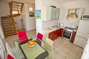 a kitchen with a glass table and red chairs at Apartments with a parking space Split - 16247 in Split