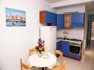 a kitchen with a table with a vase of flowers on it at Apartments by the sea Karbuni, Korcula - 16286 in Prizba