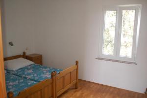 a bedroom with a bed and a window at Apartments by the sea Cove Mulobedanj, Pag - 16285 in Lun