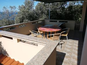 a patio with a table and chairs on a balcony at Apartments by the sea Cove Mulobedanj, Pag - 16285 in Lun