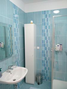 a bathroom with a sink and a shower with blue tiles at Apartments with a parking space Krapinske Toplice, Zagorje - 16290 in Krapinske Toplice