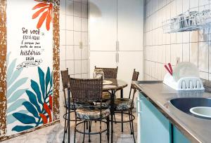 uma cozinha com uma mesa e cadeiras e um lavatório em Pousada Costa Verde em Abraão