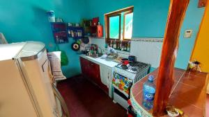 a small kitchen with a stove and a refrigerator at Hostel ZwiebeL in Santa Ana