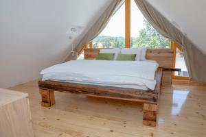 a bed in a room with a large window at Hiska B&N Podlehnik in Podlehnik