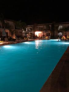 a large swimming pool with blue water at night at Boca Paraiso, Boca Chica townhouse in Boca Chica