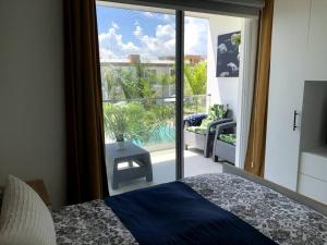a bedroom with a large glass door to a balcony at Boca Paraiso, Boca Chica townhouse in Boca Chica