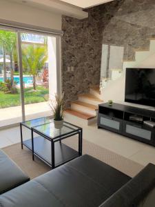 a living room with a couch and a tv and a table at Boca Paraiso, Boca Chica townhouse in Boca Chica