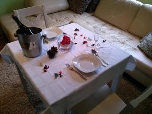einen weißen Tisch mit Tellern und Gläsern sowie eine Flasche Wein in der Unterkunft Apartments with a parking space Lovran, Opatija - 15973 in Lovran