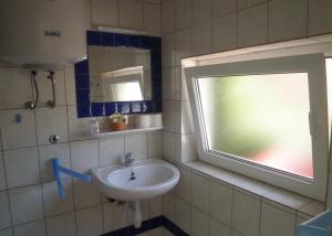 een badkamer met een wastafel en een raam bij Apartments with a parking space Punat, Krk - 15451 in Punat