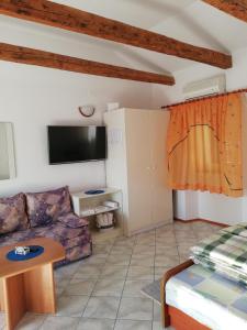 een woonkamer met een bank en een tafel bij Apartments with a parking space Punat, Krk - 15451 in Punat