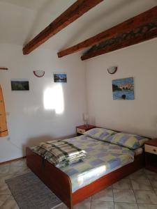 een slaapkamer met een bed in een kamer met houten plafonds bij Apartments with a parking space Punat, Krk - 15451 in Punat