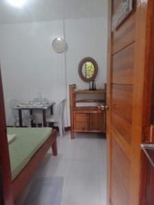 a room with a wooden door and a table and a table at Felipa Beach and Guesthouse - Newly Renovated Airconditioned Guest Rooms in Dumaguete