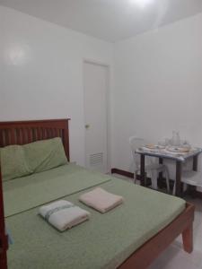 a bedroom with a bed with two pillows on it at Felipa Beach and Guesthouse - Newly Renovated Airconditioned Guest Rooms in Dumaguete