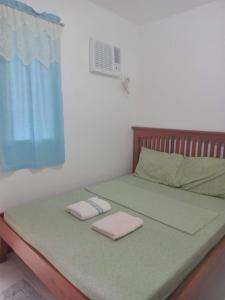a bed with two folded towels on top of it at Felipa Beach and Guesthouse - Newly Renovated Airconditioned Guest Rooms in Dumaguete