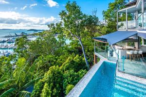 an aerial view of a house with a swimming pool and the ocean at Habitat on Hamilton Island by HIHA in Hamilton Island