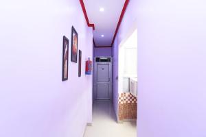 a hallway with white walls and a blue door at Hotel Rama Palace in Morādābād