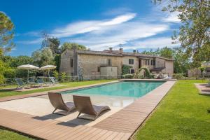 a swimming pool with two chairs and a house at Fontemaggio in Colle di Val d'Elsa