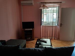 ein Wohnzimmer mit einem Sofa und einem TV in der Unterkunft Apartments with a parking space Vodice - 16060 in Vodice
