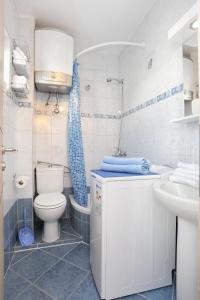 a bathroom with a toilet and a sink at Apartments by the sea Arbanija, Ciovo - 15595 in Trogir