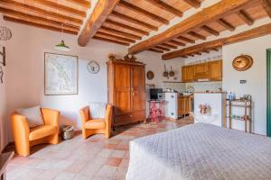 Un dormitorio con una cama y dos sillas y una cocina. en Fontemaggio, en Colle Val D'Elsa