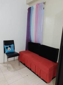 a red couch and a chair in a room at Affordable Condo for Rent in Valley Mansions in Cainta