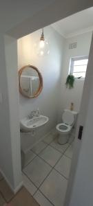 uma casa de banho com um lavatório, um WC e um espelho. em StayMore em East London