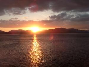 a sunset over the water with mountains in the background at The Spinnaker Hotel in Gourock