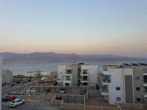 a view of a parking lot with buildings and a body of water at Dream house in Eilat