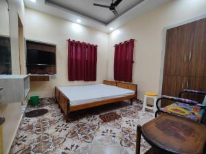 um quarto com uma cama, uma mesa e uma cadeira em Monalisa Lodge em Vishnupur