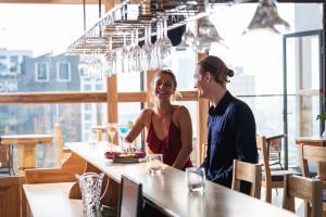 a man and a woman sitting at a table in a restaurant at Sunny Ocean Hotel & Spa in Danang