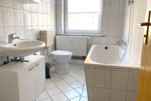 a bathroom with a sink and a toilet and a tub at Cozy Apartments in Zwickau in Zwickau