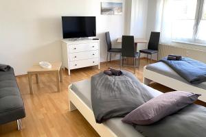 um quarto com duas camas e uma televisão e uma mesa em Cozy Apartments in Zwickau em Zwickau
