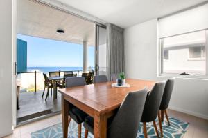 a dining room with a wooden table and chairs at Aquaview Unit 304 Kings Beach in Caloundra