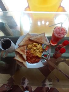 um prato de pequeno-almoço com ovos e feijões e uma bebida em Alola inn em Padangbai