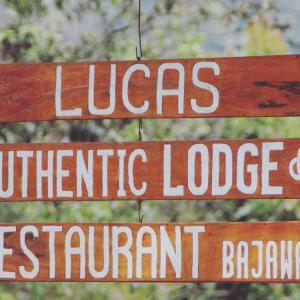 Um sinal que diz Lucas Centric Lodge e permanentario em Lucas Authentic Lodge em Bajawa