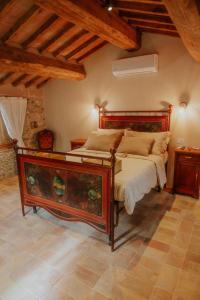 - une chambre avec un grand lit dans une pièce dotée de plafonds en bois dans l'établissement Agriturismo Podere Tovari, à Anghiari