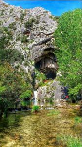 uma parede de pedra junto a um rio com uma cascata em Casa Rural las Rosas de Benaojan em Benaoján