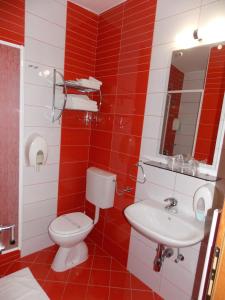 a red and white bathroom with a toilet and sink at Rooms with a parking space Oroslavje, Zagorje - 15384 in Oroslavje