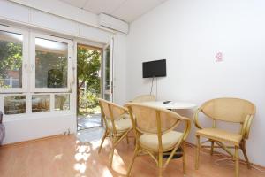 um quarto com uma mesa e cadeiras e uma televisão em Apartments with a parking space Dugi Rat, Omis - 15417 em Dugi Rat