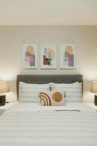 a bedroom with a large white bed with two lamps at Modern, Luxurious Apartment near Downtown Ottawa in Ottawa