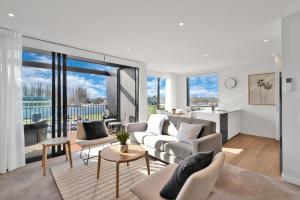 a living room with a couch and a table at Top Floor Luxury City Central w Sunny Balcony in Christchurch