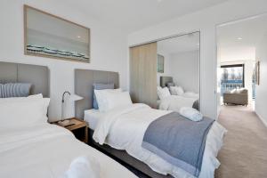 a hotel room with two beds and a mirror at Top Floor Luxury City Central w Sunny Balcony in Christchurch +22 photos