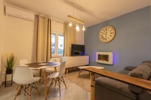 a living room with a table and a clock on the wall at Apartments with a parking space Jusici, Opatija - 15874 in Kastav