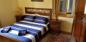 Schlafzimmer mit einem Bett mit blauer und weißer Bettwäsche in der Unterkunft Rooms by the sea Rava, Dugi otok - 15880 in Rava