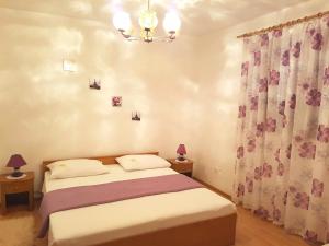 a bedroom with a bed and a chandelier at Apartments by the sea Slano, Dubrovnik - 15787 in Slano