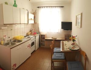 a small kitchen with a sink and a table with chairs at Apartments by the sea Slano, Dubrovnik - 15787 in Slano