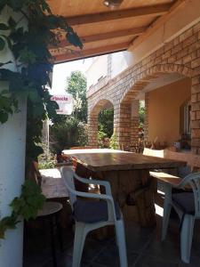 an outdoor patio with a large wooden table and chairs at Apartments by the sea Nin, Zadar - 15842 in Nin